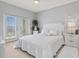 Bright bedroom with a queen bed, balcony access, and white color scheme at 808 3Rd W Ave # 514, Bradenton, FL 34205