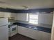 Kitchen with white cabinets, blue countertops, and appliances at 707 13Th W St, Palmetto, FL 34221