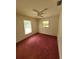 Bright bedroom with window, ceiling fan, and dark purple carpet at 707 13Th W St, Palmetto, FL 34221