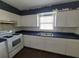 Kitchen with white cabinets, blue countertops, and appliances at 707 13Th W St, Palmetto, FL 34221