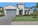Two-story home with gray garage door, paved driveway, and landscaped lawn at 17931 Palmiste Dr, Bradenton, FL 34202