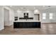 Modern kitchen with large island, white and dark cabinets, and quartz countertops at 17931 Palmiste Dr, Bradenton, FL 34202