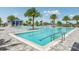 Community lap pool with a paved deck, palm trees, and a pool house at 17931 Palmiste Dr, Bradenton, FL 34202