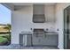 Outdoor kitchen with a grill, sink, and mini-fridge at 17931 Palmiste Dr, Bradenton, FL 34202