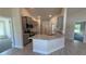 Modern kitchen featuring stainless steel appliances, gray cabinets, a granite countertop island, and wood-look tile flooring at 3884 S Haberland Blvd, North Port, FL 34288