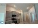 Well-lit kitchen with stainless steel appliances, granite counters, gray cabinetry, and wood-look tile flooring at 3884 S Haberland Blvd, North Port, FL 34288