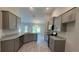 Spacious kitchen boasting stainless steel appliances, gray cabinetry, granite countertops, and wood-look tile flooring at 3884 S Haberland Blvd, North Port, FL 34288
