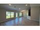Bright living room showcasing wood-look tile flooring, recessed lighting, and access to the kitchen and backyard at 3884 S Haberland Blvd, North Port, FL 34288