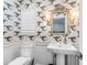Charming powder room with unique wallpaper and a pedestal sink at 5727 Riegels Point Rd, Sarasota, FL 34242