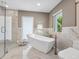 Spa-like bathroom with a freestanding tub, glass shower, and marble tile at 5727 Riegels Point Rd, Sarasota, FL 34242