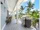 Spacious deck with built-in grill, wicker furniture, and tropical views at 5727 Riegels Point Rd, Sarasota, FL 34242