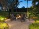 Evening view of fire pit with comfortable seating and landscape lighting at 5727 Riegels Point Rd, Sarasota, FL 34242