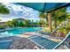 Relaxing community pool with lounge chairs and umbrellas at 8214 Las Lilias Ct, Sarasota, FL 34243