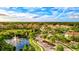 Aerial view of community featuring lush landscaping, pool, and pond with fountain at 8214 Las Lilias Ct, Sarasota, FL 34243