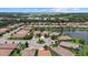 Aerial view showcasing community with lake, homes, and landscaping at 8214 Las Lilias Ct, Sarasota, FL 34243