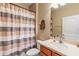 Clean bathroom with tub shower combo, vanity, and striped shower curtain at 8214 Las Lilias Ct, Sarasota, FL 34243