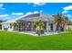 Backyard view of a home with a pool and lush landscaping at 158 Allworthy St, Port Charlotte, FL 33954
