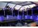 Enclosed pool area with colorful night lighting and seating at 11061 Sandrift Ave, Englewood, FL 34224