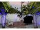 Landscaped backyard with brick patio, seating, and grill at 11061 Sandrift Ave, Englewood, FL 34224
