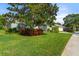 Front yard with a large tree, colorful shrubs, and a green lawn at 1206 86Th Nw Ct, Bradenton, FL 34209