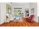 Living area with hardwood floors, a white couch, red armchair and backyard view at 1206 86Th Nw Ct, Bradenton, FL 34209