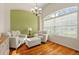 Cozy sitting room with hardwood floors, two armchairs, ottoman and green accent wall at 1206 86Th Nw Ct, Bradenton, FL 34209