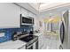 Updated kitchen featuring modern stainless steel appliances, white cabinets and a cozy breakfast nook at 3705 E Bay Dr # 115, Holmes Beach, FL 34217