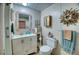 Bright bathroom with a white vanity, decorative mirror, and coastal-themed accents at 6428 Fleetwood Ct, North Port, FL 34287