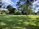 Expansive green lawn with mature trees and manicured landscaping at 3500 El Conquistador Pkwy # 307, Bradenton, FL 34210