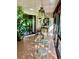 Bright sunroom with glass-top table, wicker chairs, and terracotta tile floor at 3500 El Conquistador Pkwy # 307, Bradenton, FL 34210