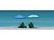 Couple relaxing on the beach under umbrellas at 549 Sloop Ln, Longboat Key, FL 34228