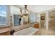 Spa-like bathroom with soaking tub and large mirror reflecting the room at 549 Sloop Ln, Longboat Key, FL 34228