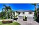 Two story home with gray double garage doors and tropical landscaping at 549 Sloop Ln, Longboat Key, FL 34228
