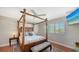 Guest bedroom with a four-poster bed and window shutters at 549 Sloop Ln, Longboat Key, FL 34228