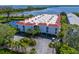 Aerial view of condo building with red tile roof, and lush landscaping at 3705 E Bay Dr # 115, Holmes Beach, FL 34217