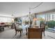 Bright dining room with glass table and chandelier, leading to a balcony at 1477 Park Beach Cir # 13, Punta Gorda, FL 33950