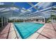 Community pool with covered seating area and surrounding lush landscaping at 1477 Park Beach Cir # 13, Punta Gorda, FL 33950