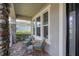 Covered front porch with wicker seating and tile flooring at 5228 Bentgrass Way, Bradenton, FL 34211