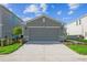 View of the two-car garage on a home with a well-kept lawn and simple landscaping at 5917 Laurelcrest Gln, Palmetto, FL 34221