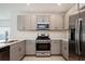 Modern kitchen with light gray cabinets, stainless appliances and light countertops at 5917 Laurelcrest Gln, Palmetto, FL 34221