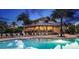 Exterior view of the clubhouse featuring an inviting pool area with ample seating and umbrellas at 5917 Laurelcrest Gln, Palmetto, FL 34221