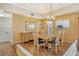 Elegant dining room with wood floors and a modern chandelier at 2517 Glebe Farm Close # H-2, Sarasota, FL 34235