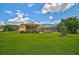 Expansive backyard featuring a screened lanai, outdoor kitchen, lush lawn and garden at 14526 17Th E Ave, Bradenton, FL 34212