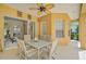 Covered patio with dining table, ceiling fan, and view of the interior through sliding glass doors at 14526 17Th E Ave, Bradenton, FL 34212