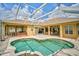 Spacious screened-in pool area features a spa, covered patio, and outdoor kitchen at 14526 17Th E Ave, Bradenton, FL 34212
