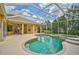 Beautiful backyard features a screened-in pool, spa, covered patio, and lush landscaping at 14526 17Th E Ave, Bradenton, FL 34212