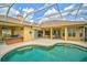 Backyard oasis features a screened-in pool, spa, covered patio, and outdoor kitchen at 14526 17Th E Ave, Bradenton, FL 34212