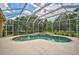 A beautiful, screened-in pool and spa are surrounded by lush landscaping at 14526 17Th E Ave, Bradenton, FL 34212