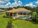 Aerial view of a screened in pool and spa, surrounded by lush landscaping and a pristine lawn in the backyard at 14526 17Th E Ave, Bradenton, FL 34212
