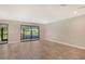 Spacious living room with wood-look floors and sliding glass doors at 7301 Ballantrae Pl # 27D, Sarasota, FL 34238